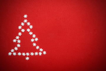 Naklejka na ściany i meble Minimal christmas background with christmas tree made of snowflakes on red background. Minimal concept. Top view, copy space