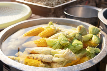 Sweet corn boiling in the pot at street food market. 