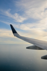 Obraz premium Wing of an airplane flying above the clouds