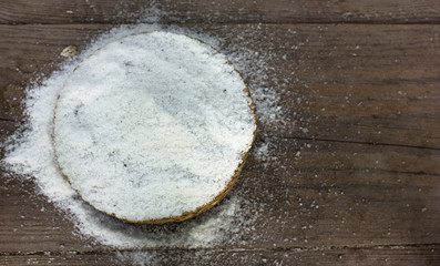 Crystals of shallow salt in a wooden bowl on a dark gray table. Background for advertising salt. Table salty. Salted food.