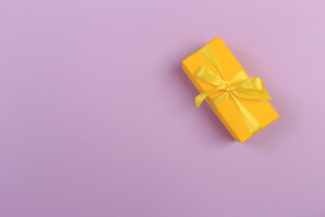 Gift box with ribbon and bow on color background and space for text. Top view - Image