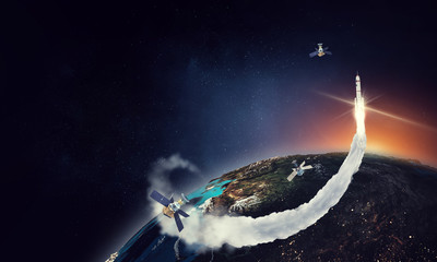 Obraz na płótnie Canvas Erath upper surface with flying satellites and a rocket