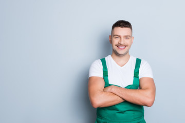 Photo of handsome virile muscles guy holding arms crossed self-confident best manual worker skilled engineer wear green safety dungarees isolated grey background