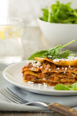 Traditional Homemade Italian Lasagna with Tomato Sauce Isolated on White Background. Hot Tasty Lasagna or Lasagna with Parmesan Cheese on Elegant Restaurant Plate Close Up
