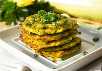 Pan fried zucchini fritters, traditional flat zucchini pancakes with garlic and green parsley