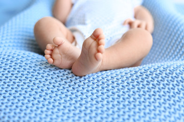 Cute little baby lying on light blue plaid, closeup