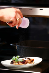cropped view of woman powdering traditional homemade fruit cake with icing sugar