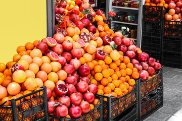 Crates with piles of different fresh fruits near shop outdoors