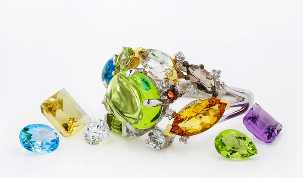 Golden ring. Golden ring with citrine, diamond; garnet, sapphire, chrysolite, amethyst, smoky quartz, emerald, topaz on white background.