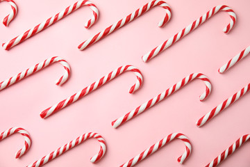 Flat lay composition with candy canes on pink background