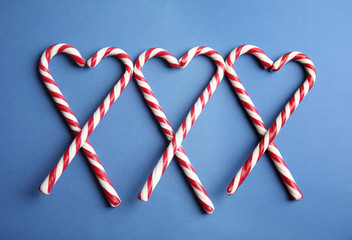 Candy canes on blue background, flat lay