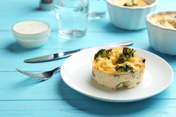 Tasty broccoli casserole served on blue wooden table