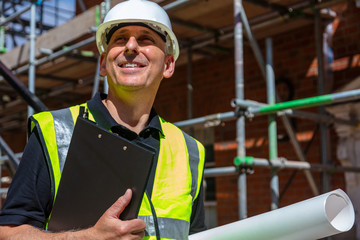Male Builder Architect Contractor on Building Site Clipboard and Plans