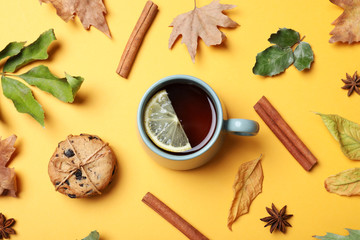 Flat lay composition with cup of hot drink on yellow background. Cozy autumn atmosphere