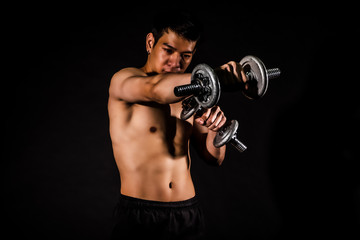 Fototapeta na wymiar sport man standing doing exercise for arms with dumbbells and showing muscle bodybuilding on black backgrounds, fitness concept, sport concept