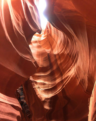 Looking up at Low Antelope canyon, stunning view, eroded red sandstone walls, sun light falling on red canyon walls directly above