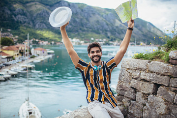 Handsome bearded tourist with backpack is making travel across city.