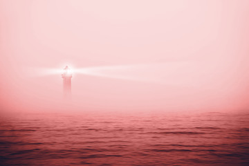 Lonely lighthouse in a misty sea.  Coral - Color of the Year 2019