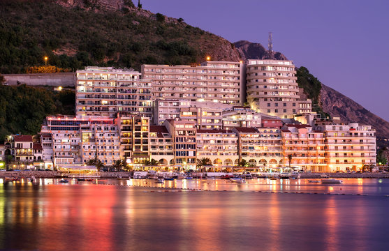 resort area with beaches and bright lights and highlights in the water night sea coast against the backdrop of mountains sunset in Montenegro Budva Rafailovici