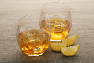 Two glasses with whiskey with ice cubes	