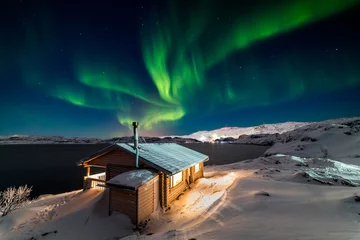 Aluminium Prints Northern Lights Wooden cottage on the background of the Northern Lights at night.
