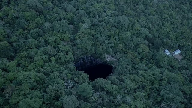 AERIAL TILT DOWN REVEAL -Amazing Cave of Swallows (Schwalbenhohle) deep in the heart of the jungle in Mexico.
