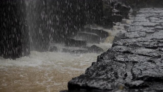 CU SLOWMOTION - Water particles splashing on the ground at the bottom of a waterfall in Pachuca, Mexico.