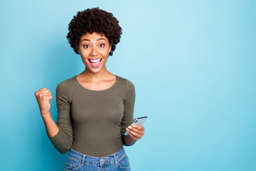 Yes more followers. Portrait of cheerful curly hair girl hold use smartphone get notification...