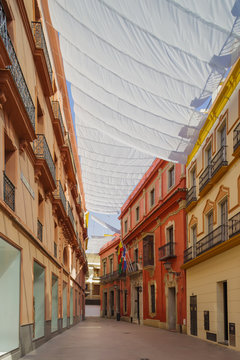 A Siesta Time. The Empty Street Under The Protection Of Shadow Curtains. Seville, South Of Spain.