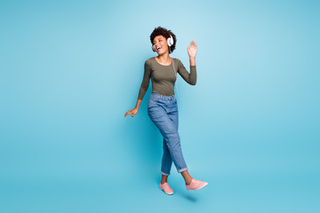 Full length body size photo of cheerful excited cute ecstatic careless black clubber hanging out in jeans denim green shirt dancing isolated over blue vivid color background