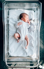 Newborn boy sleeping in his hospital bed