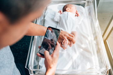 Unrecognizable father taking a photo to his son in hospital. Family concept