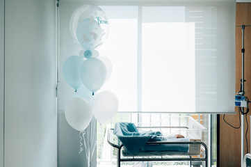 Hospital bed for a newborn with blue balloons