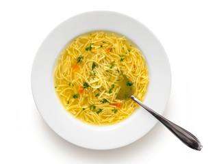 Instant chicken noodle soup in a white ceramic soup plate with metal spoon isolated on white. Top...