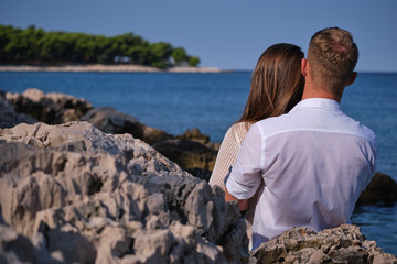 Couple in love having romantic tender moments on the beach - Young lovers kissing in summer vacation next to the ocean - Love, holidays and travel concept