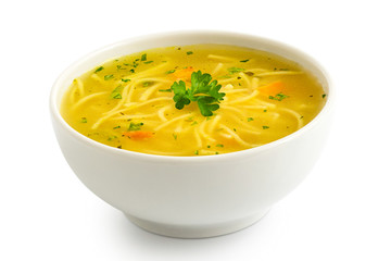 Instant chicken noodle soup in a white ceramic bowl isolated on white. Parsley garnish. - obrazy, fototapety, plakaty
