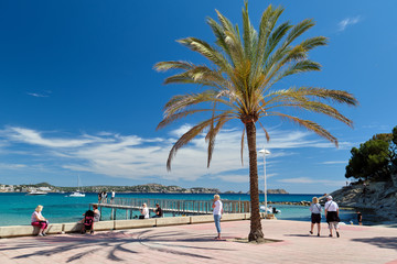 People enjoy summer holidays walking enjoy picturesque views picturesque seaside Mediterranean Sea turquoise bay, hills and wooden boardwalk, Majorca Island Baleares Spain