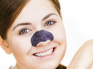 Woman applying pore strips on nose