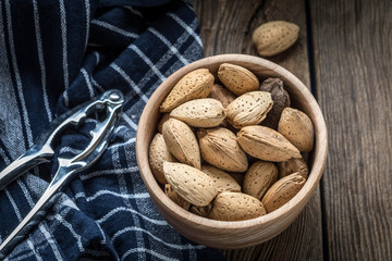 Almonds in-shell in wooden bowl.
