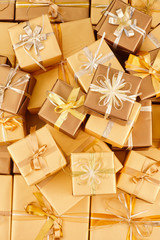 many golden gift boxes with ribbons lie on the table