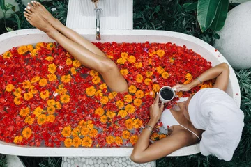Foto op Canvas Vrouw ontspannen in buitenbad met bloemen in Bali spa hotel. © Alena Ozerova