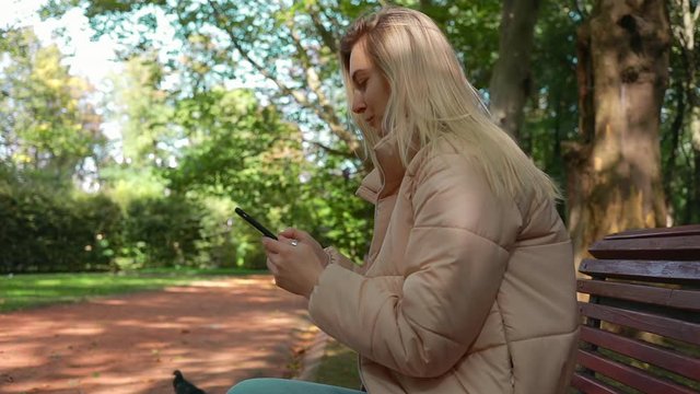 Beauty caucasian woman sitting in park, girl use smartphone in social internet media technology 5g