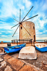 A big brick windmill with three old fish boats, Corfu, Greece © Dmitry Chumichev
