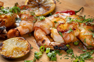 Shrimp shrimp, decorated with herbs, next to the grilled lemons.