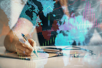 Multi exposure of woman's hands making notes with forex graph hologram. Concept of technical analysis.