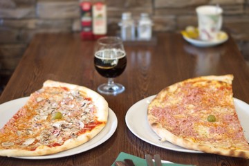 Two slices of pizza served on the wooden table