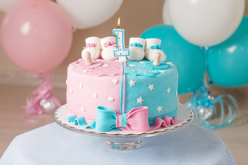 Obraz na płótnie Canvas Colorful decoration of a first year birthday cake for twins. Happy birthday. White, pink, blue colors