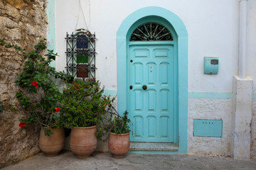 Fototapeta na wymiar Facade of a traditional house with pot plants in the medina of Asilah