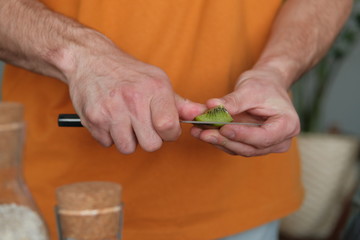 Man cuts kiwi for smoothie. 