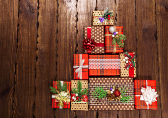 Christmas Tree made of beautifully packaged gifts with christmas decoration on wooden background closeup